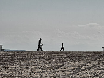Silhouette people against sky
