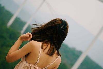 Rear view of a young woman standing outdoors