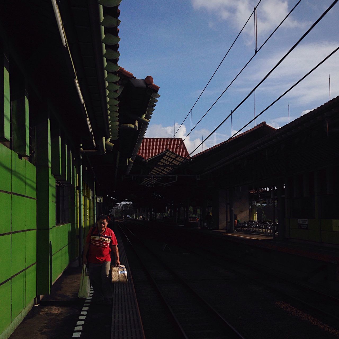 railroad track, transportation, rail transportation, railroad station platform, railroad station, public transportation, built structure, architecture, the way forward, building exterior, power line, sky, cable, train - vehicle, travel, city, diminishing perspective, connection, railway track, vanishing point