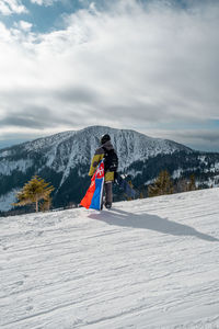 Rear view of woman skiing on snow covered landscape
