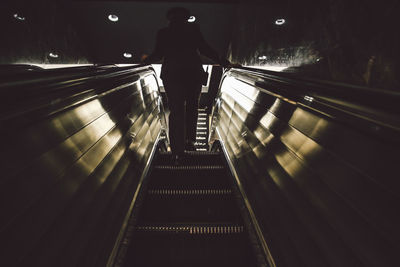 Rear view of woman on escalator