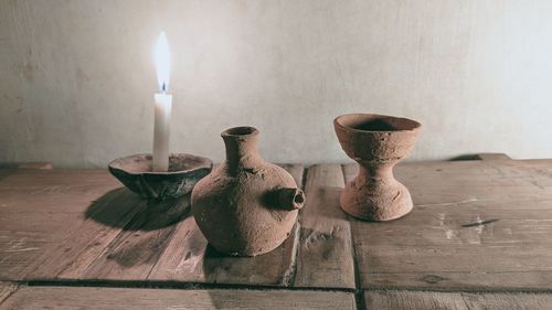 Close-up of candles on table against wall