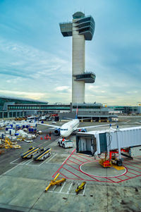 Airplane on airport runway against sky