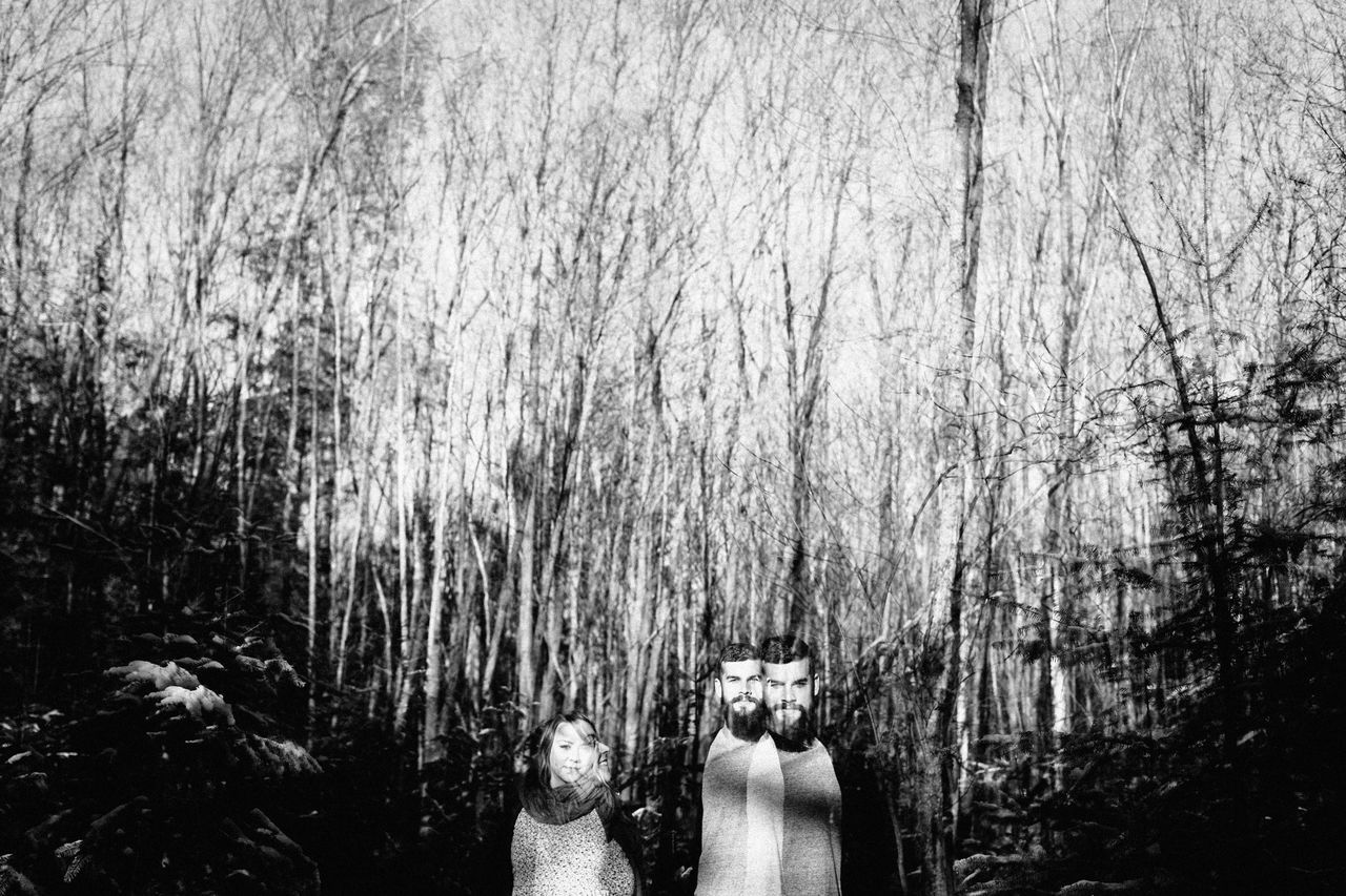 LOW SECTION OF MAN AND WOMAN STANDING IN FOREST