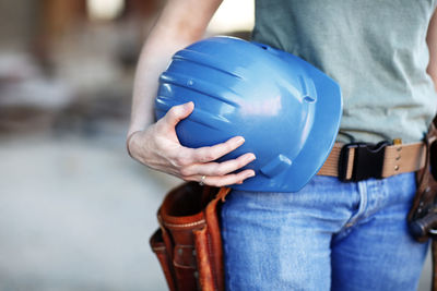 Close up of a female construction worker holding a hard hat