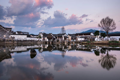 Reflection of buildings in lake against sky