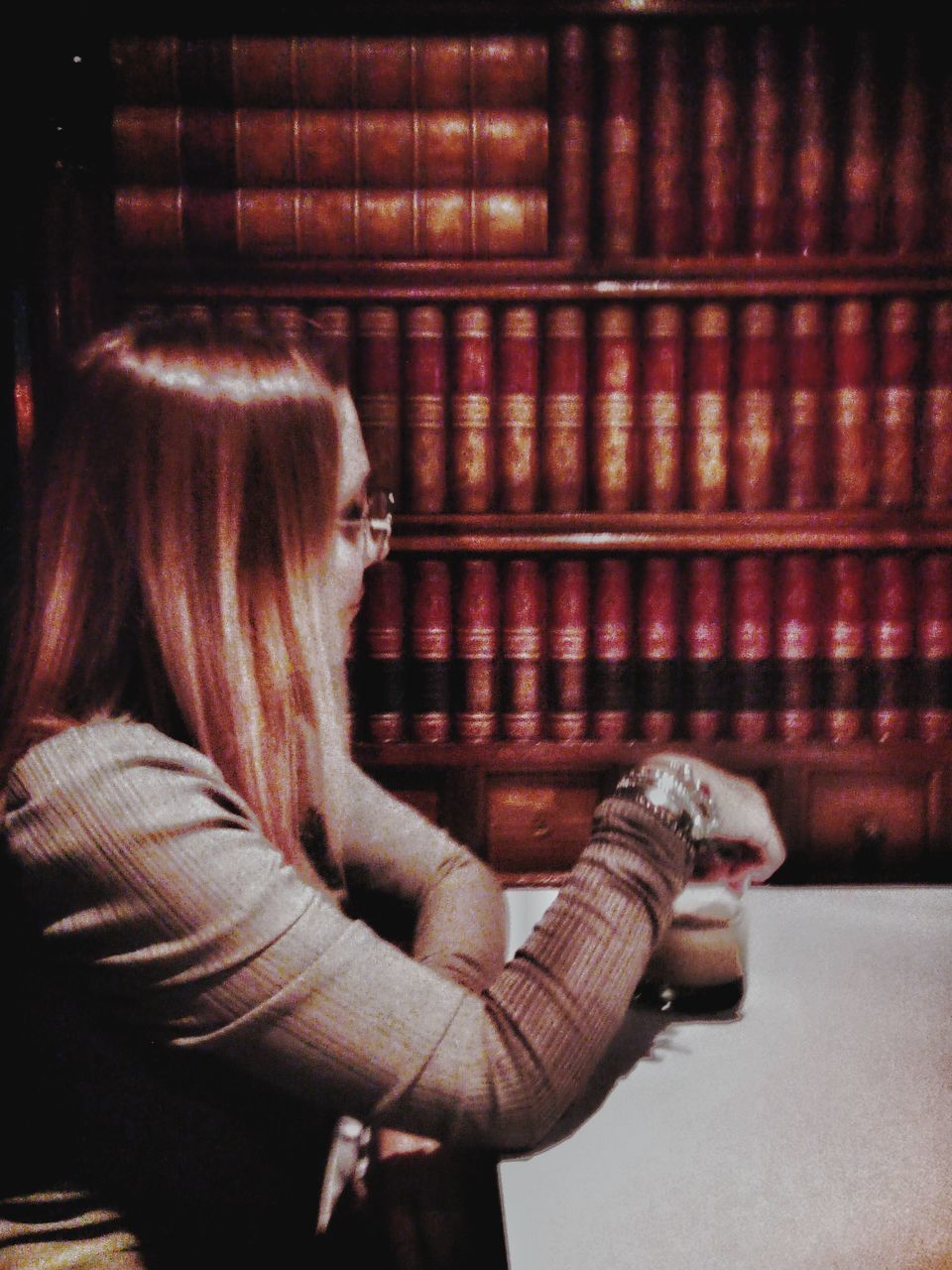 SIDE VIEW OF WOMAN SITTING ON BOOK