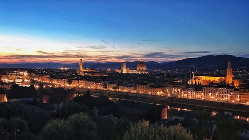 High angle view of illuminated city against sky at sunset