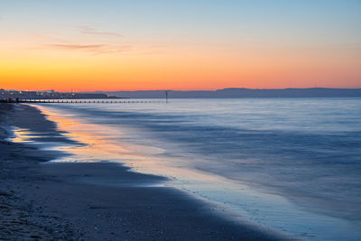 Scenic view of beach against sky during sunset