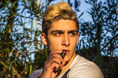 Portrait of young man smoking cigarette