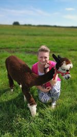 Full length of woman with dog on field