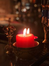 Close-up of burning candle on table