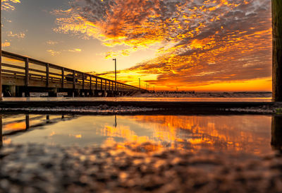 Bridge over sea against sky during sunset
