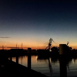 Silhouette boats in calm sea at sunset