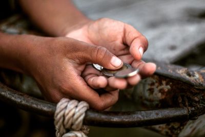 Cropped hands of man holding coins outdoors