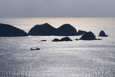 Scenic view of rocks in sea against sky