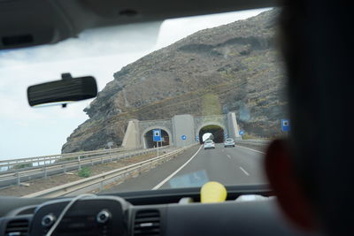 Cars moving on road seen through car windshield