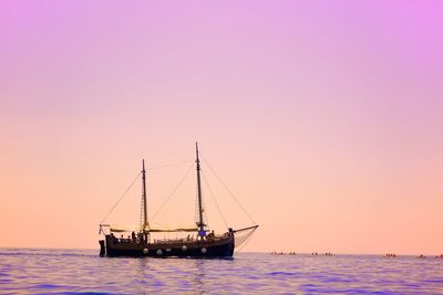 Boat sailing in sea at sunset