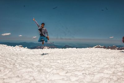 Full length of boy jumping on beach against sky