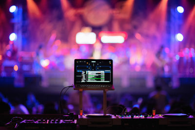 Close-up of sound mixer against illuminated defocused lights at night