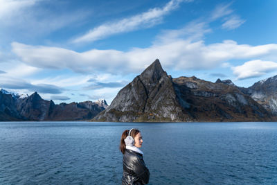 Man standing by lake against sky