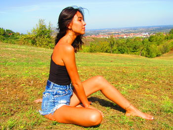 Side view of young woman lying on field
