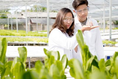 Woman holding umbrella in greenhouse