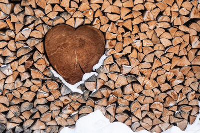 Wood for the fireplace arranged in an artistic way with a wooden heart. natural wood background.