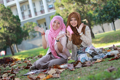 Full length of smiling woman sitting outdoors