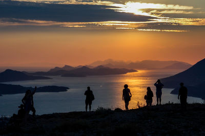 Silhouette of people at beach during sunset