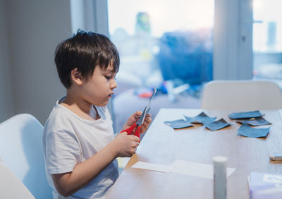 Boy looking at camera while sitting at home