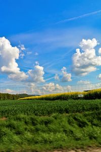 Scenic view of field against cloudy sky