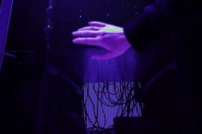 Close-up of hand against purple curtain