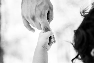 Cropped image of father holding child hand