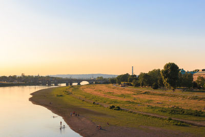 Scenic view of river against clear sky during sunset