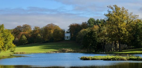 Scenic view of lake by trees against sky