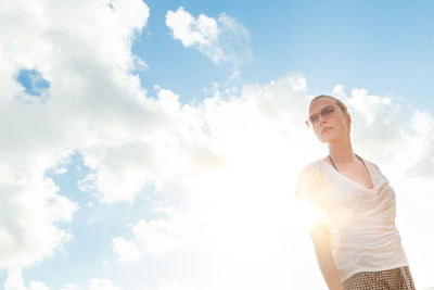 Low angle view of woman standing against sky