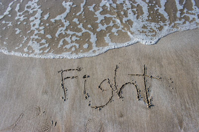 High angle view of text on sand at beach