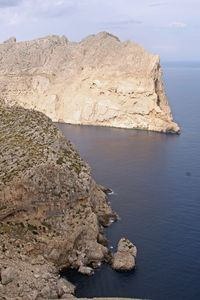 Rock formations by sea against sky