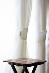 Empty bench on table against wall