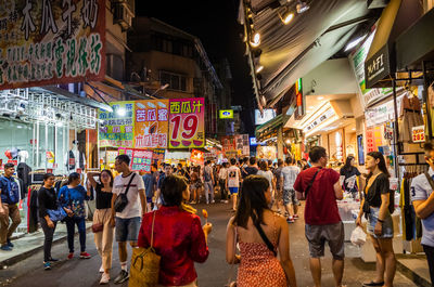 People walking on city street at night