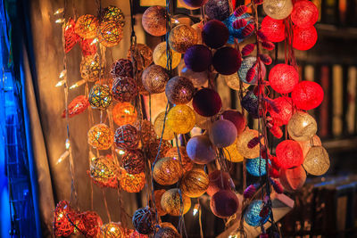 Illuminated lanterns hanging in market for sale