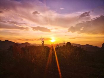 Scenic view of silhouette field against sky during sunset