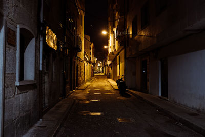 Street amidst illuminated buildings in city at night