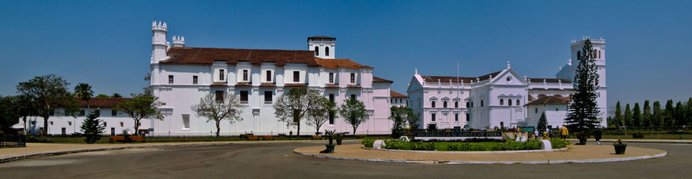 Street amidst buildings against clear blue sky