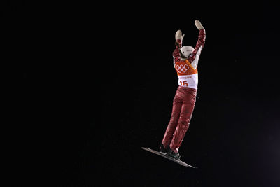 Midsection of man jumping against black background