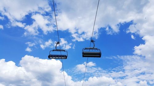 Low angle view of overhead cable car against sky