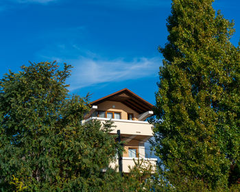 Low angle view of trees and building against sky