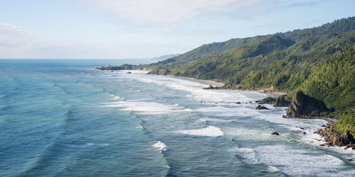 Rough exotic coast with azure ocean water, big waves and rainforest vegetation, new zealand