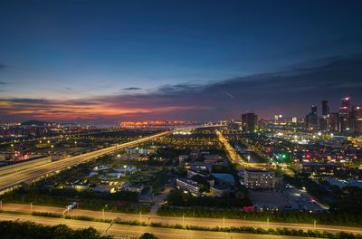 High angle view of illuminated buildings against sky at night